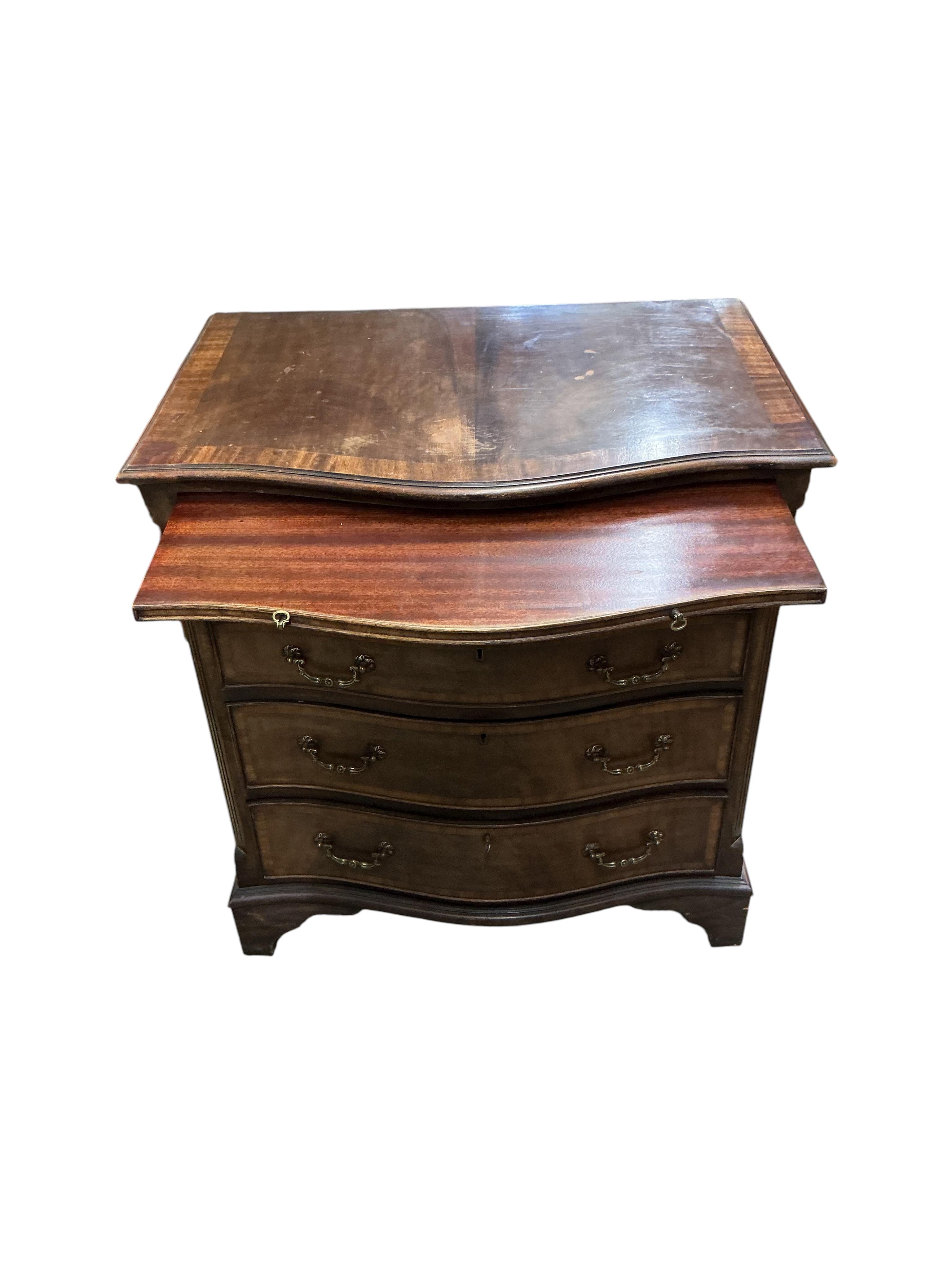 A pair of reproduction George III style serpentine mahogany four drawer chests with brushing slides, width 71cm, depth 49cm, height 77cm